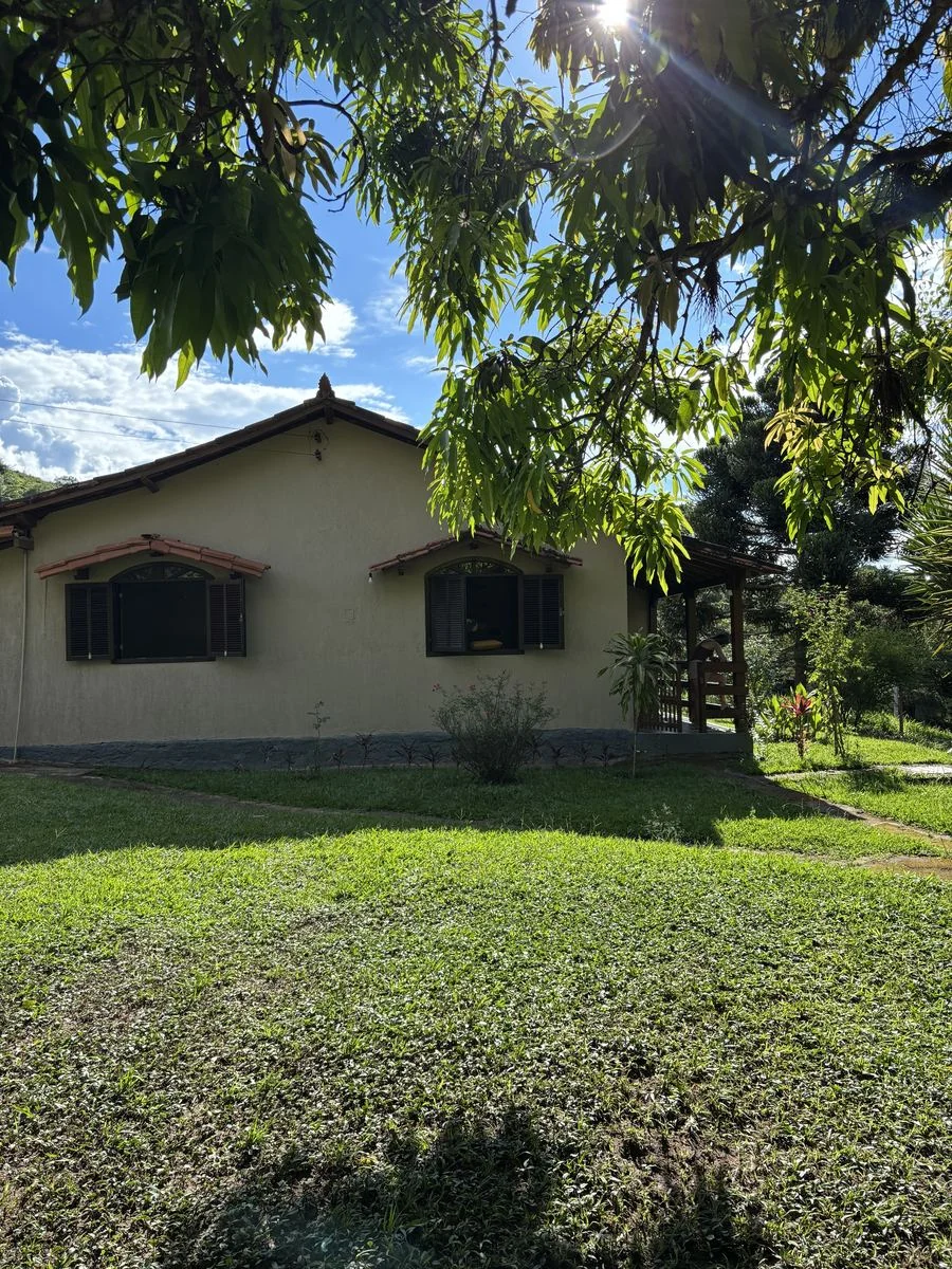 Fachada da casa do Sítio da Barra entre árvores e gramado
