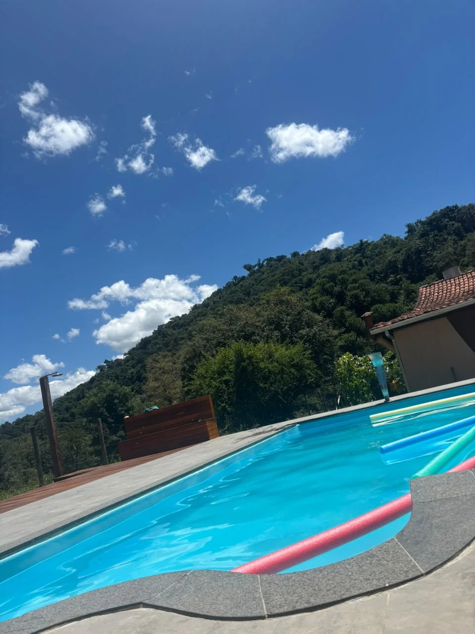 Piscina com céu azul e montanhas ao fundo